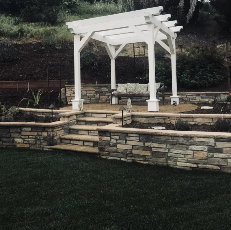 Pacific Landscape Services — pergola with stone veneer raised planters